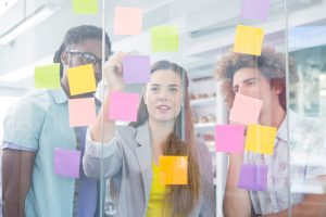 Creative business team writing on adhesive notes in office
