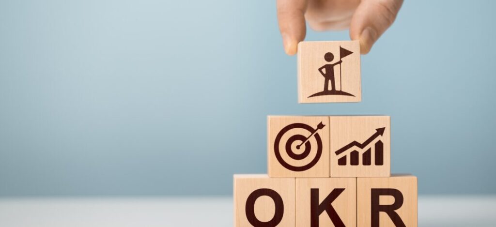 Equipe de gestão analisando painel de OKRs e fluxo de processos em escritório moderno